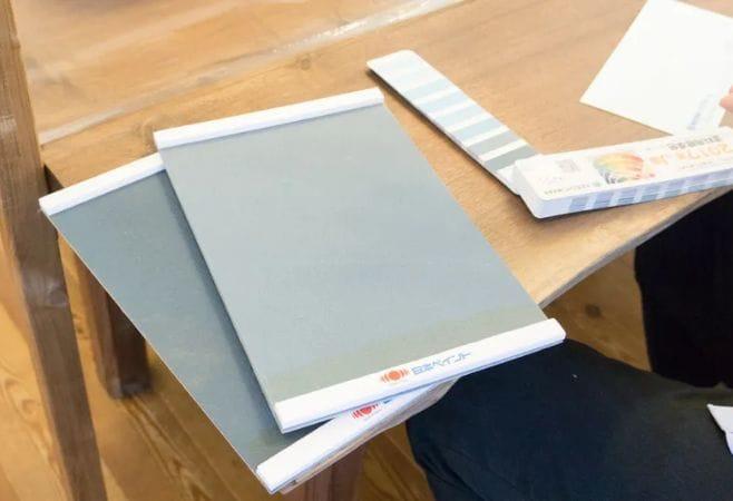 テーブルの上に色見本が2枚用意されている。それぞれ微妙に異なるグレーで、横25cm、縦30cmほどの大きさ。